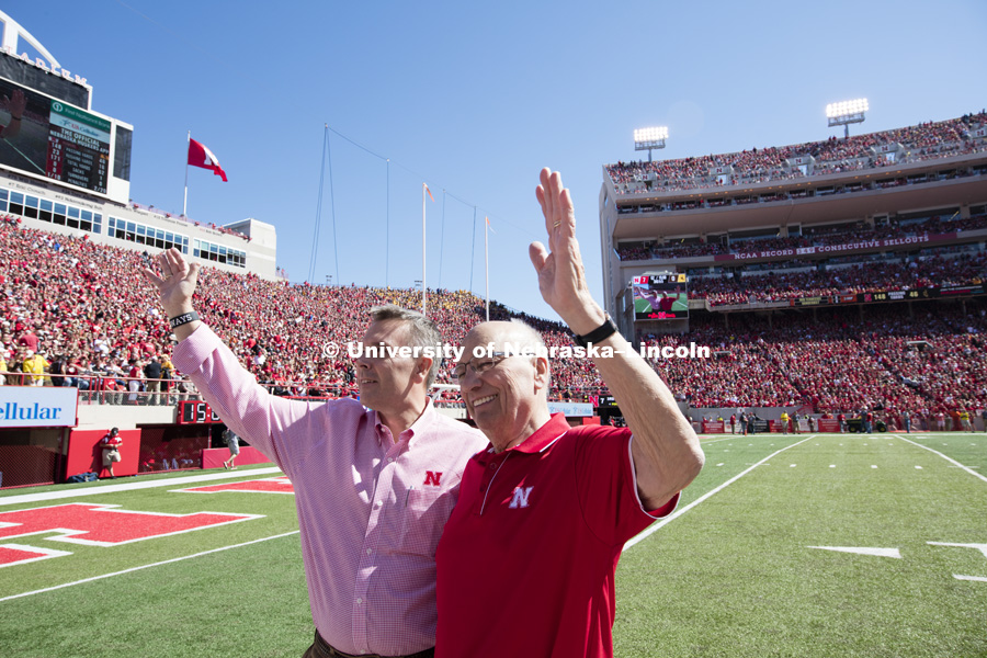 Former United States Agriculture Secretery Clayton Yeutter, right, and University of Nebraska Chancellor Ronnie Green wave to the crowd after Yeutter was honored on the field between the first and second quarters. Nebraska vs. Wyoming football. September 10, 2016. Photo by Craig Chandler / University Communication Photography.